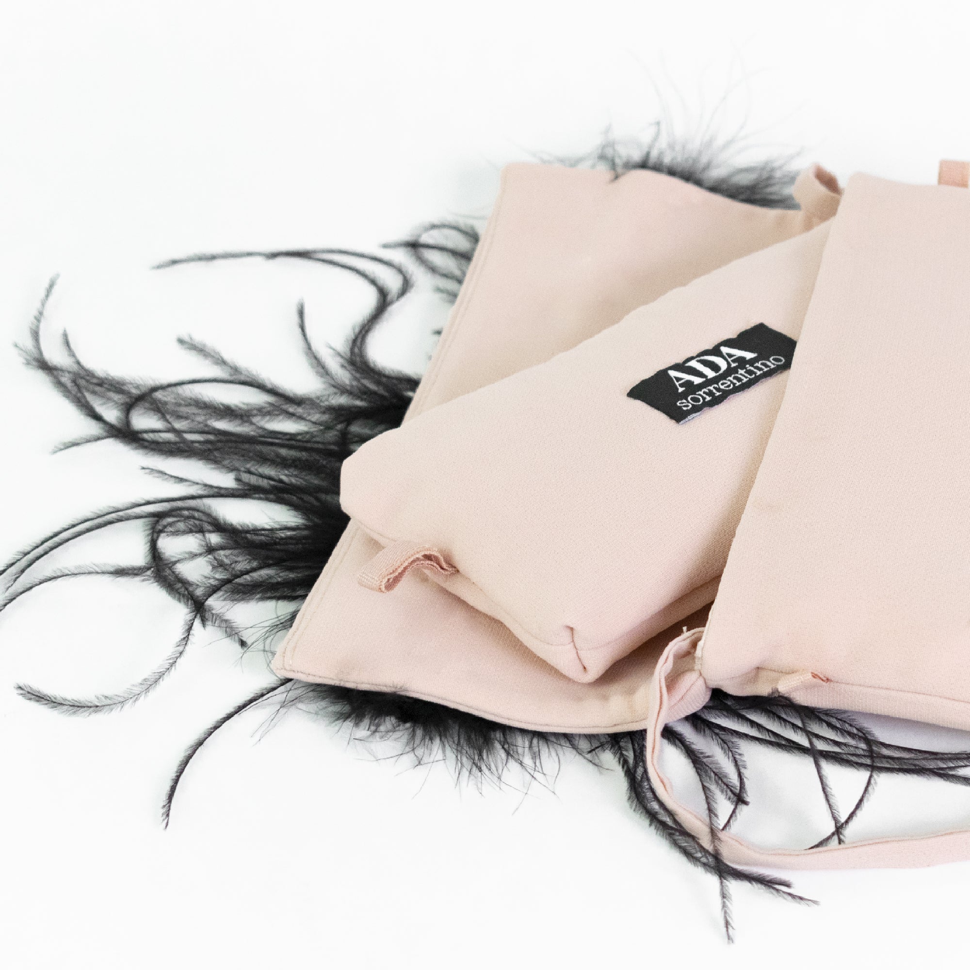 Pink clutch bag with black feathers